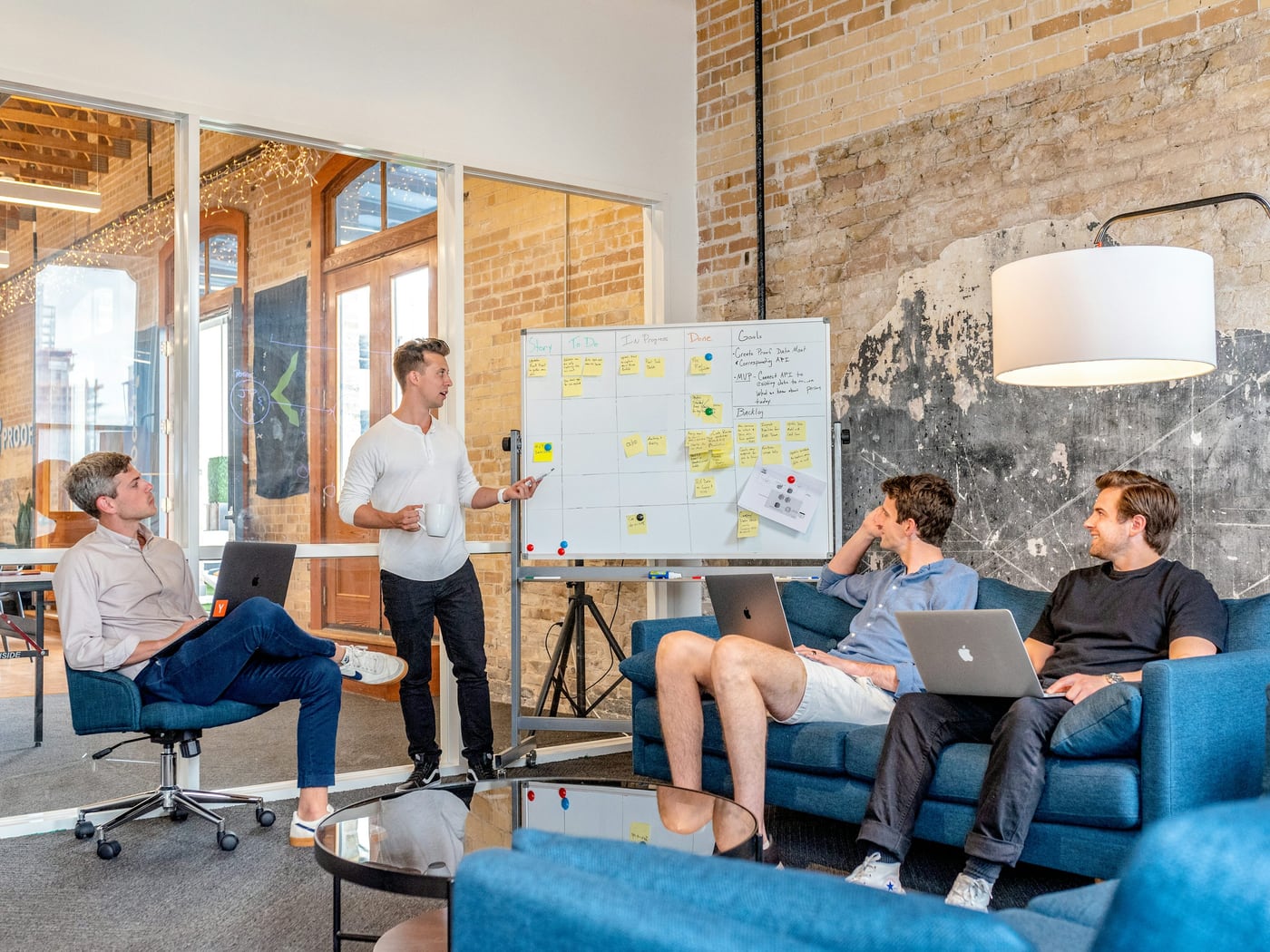 Software team discussing work beside a whiteboard
